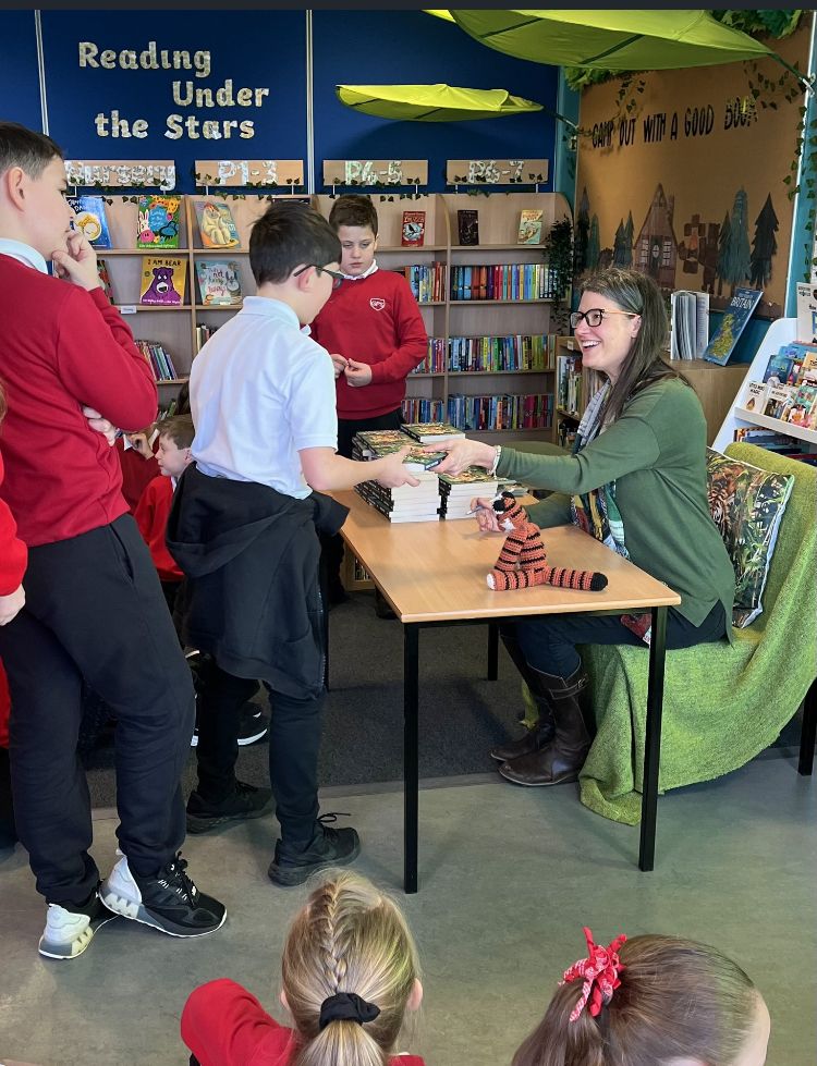 Author signing books in school library