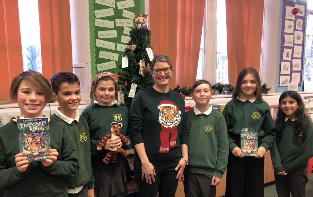 Author and six children at Christmas tree with Tiger Skin Rug book.